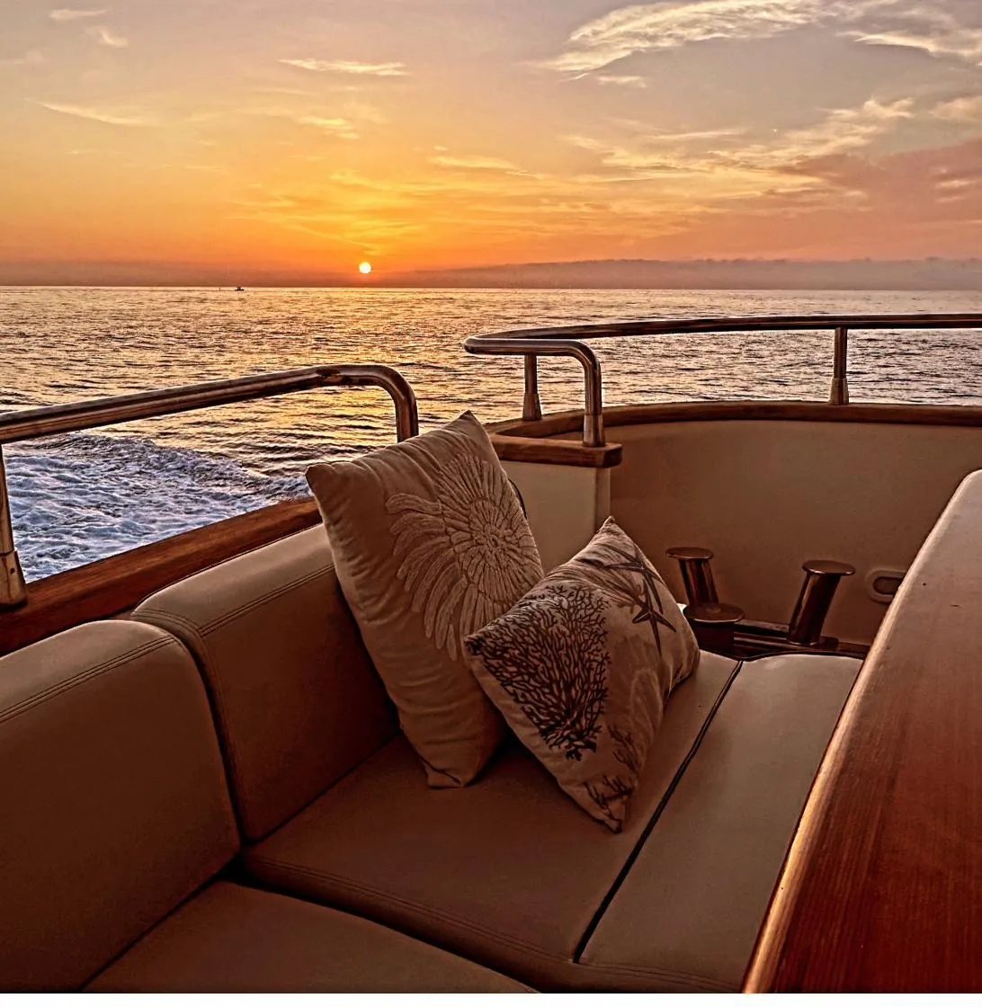 Cushions on the bow at sunset, the sea flat to the horizon