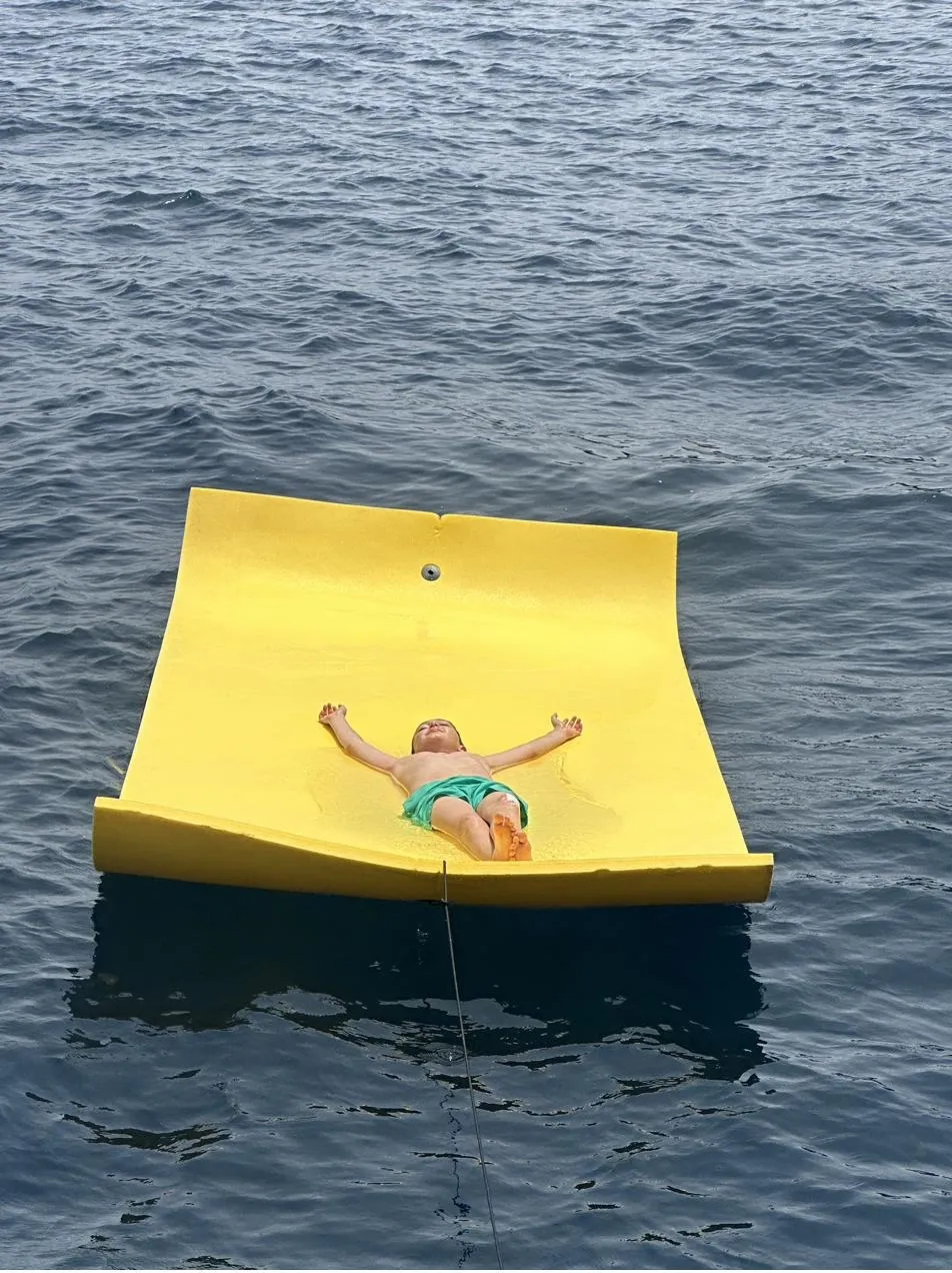 The yellow floating mat on flat water, seen from above