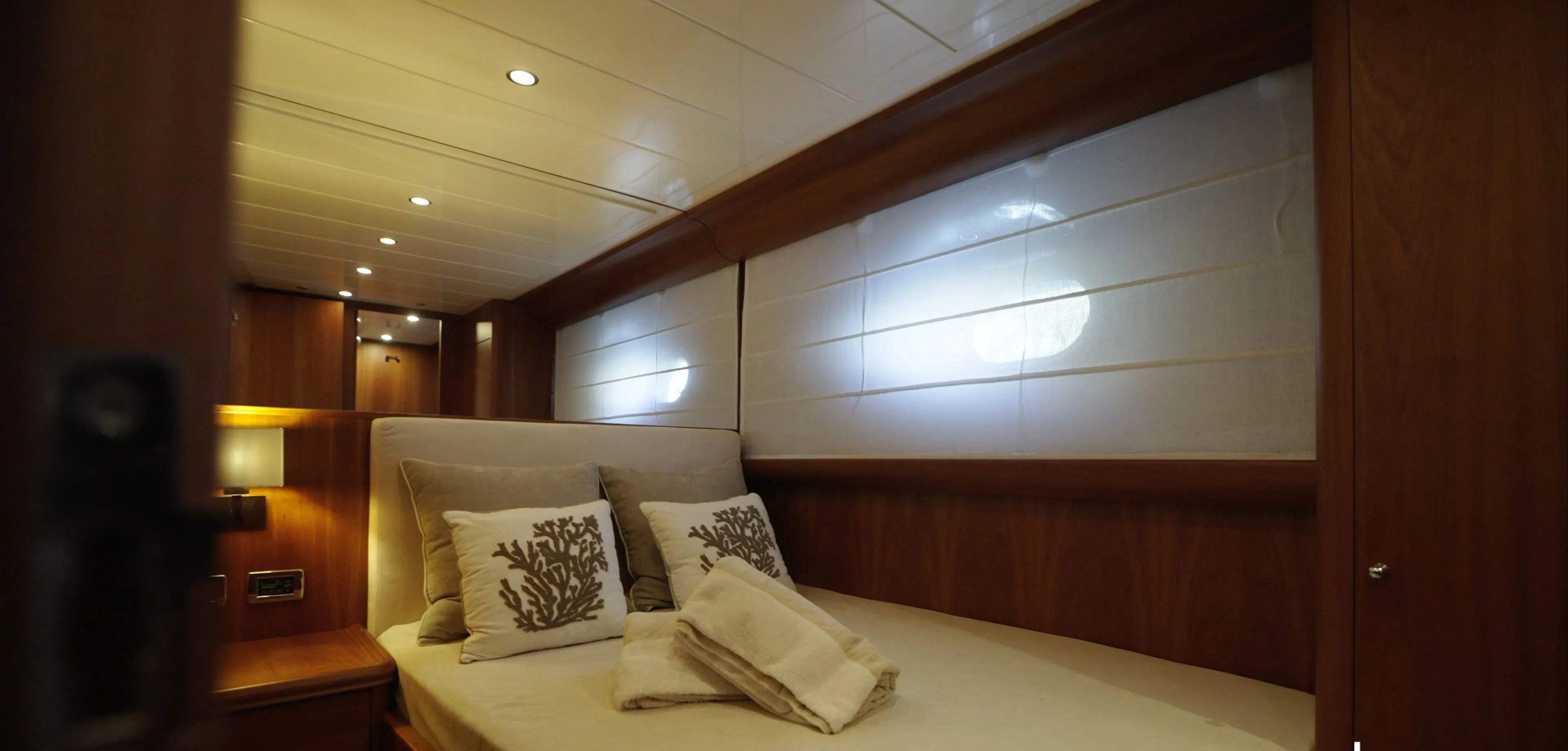 The Filicudi suite, queen size bed beneath a long window with the blind drawn